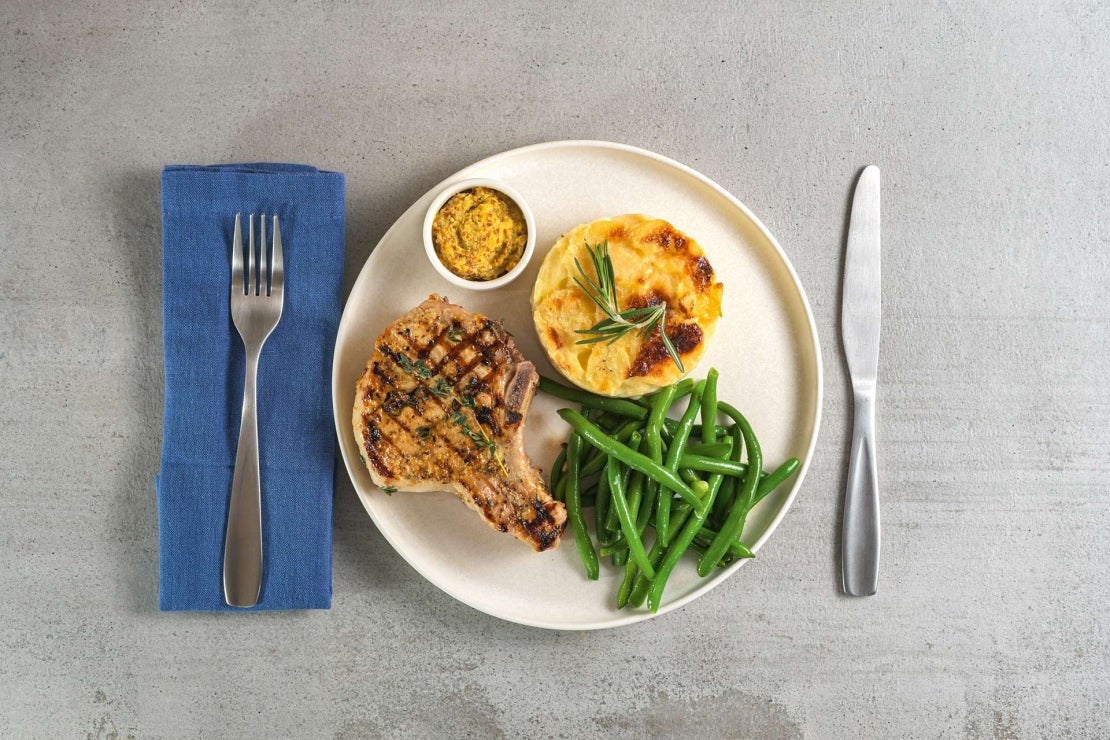 Gegrillte Schweinekoteletts, grüne Bohnen und Kartoffelgratin