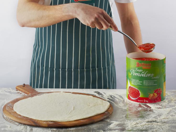 Person mit Buitoni Tomaten und Pizzateig